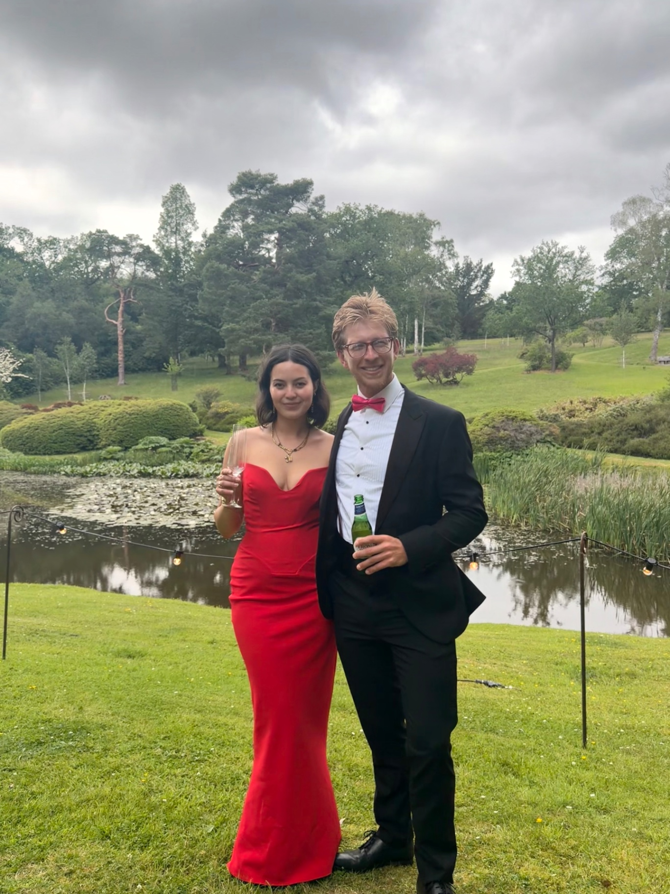 Jono & Monika by a pond — Monika in a red gown, Jono in a tuxedo