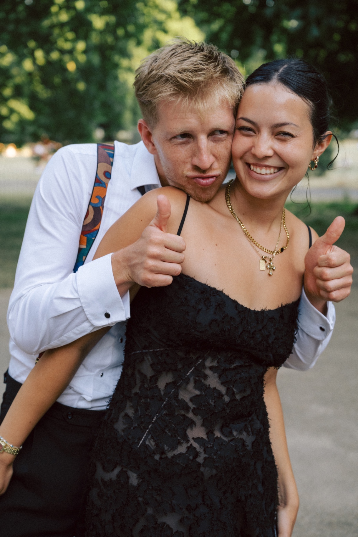 Jono grinning behind Monika with two thumbs up